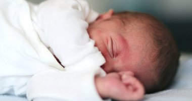 Baby newborn waking up from nap stretching body