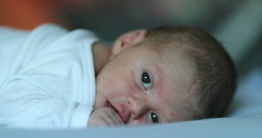 Adorable newborn baby infant smiling feeling happy discovering the world