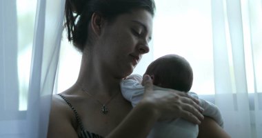 Mother holding newborn born baby showing love and affection