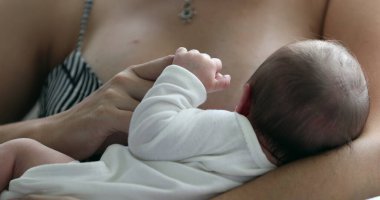 Newborn baby in mother arms, little baby holding mom finger