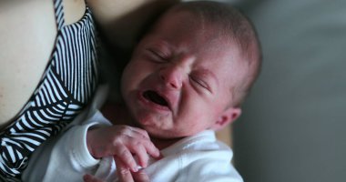 Newborn baby crying in mother arm