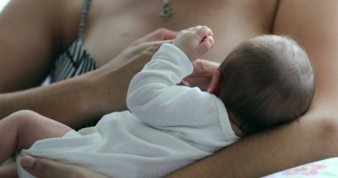 Mother holding newborn baby in her arms after birth