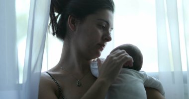 Mother holding newborn born baby showing love and affection