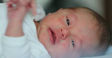 Small Newborn baby infant lying in bed, close-up of baby face