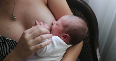 Mother breastfeeding newborn baby infant