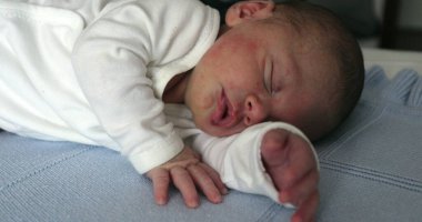 Yeni doğmuş bebek yatakta uyuyor.