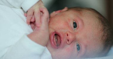 Small Newborn baby infant lying in bed, close-up of baby face