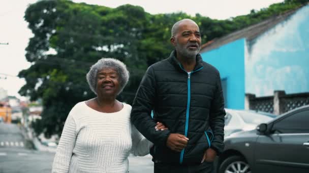 非洲裔美国人成年儿子与年迈的母亲在城市里散步 老年妇女与照顾者在户外挽臂散步 — 图库视频影像