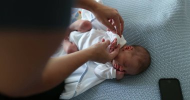Newborn baby taking a nap mother adjusting clothes