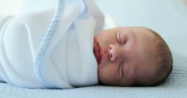 Newborn baby sleeping covered with blanket