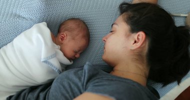 Mother and newborn baby sleeping napping together