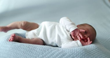 Newborn baby waking up stretching body