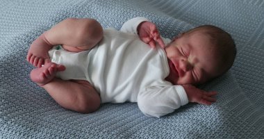Newborn baby falling asleep stretching body taking a nap sleepy