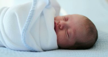 Newborn baby sleeping covered with blanket