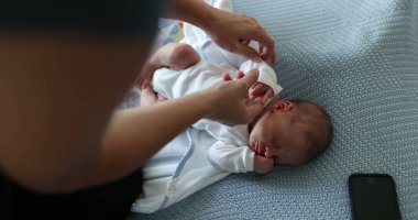 Newborn baby taking a nap mother adjusting clothes
