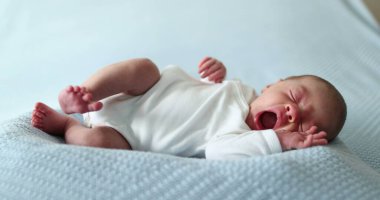 Newborn baby falling asleep taking a nap yawning and going to sleep