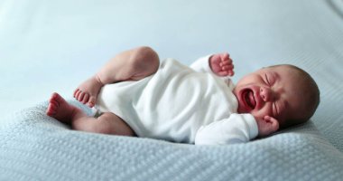 Newborn baby waking up stretching body