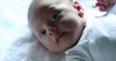Newborn baby first days of life looking at camera