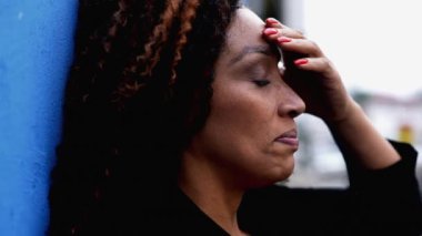 50 'li yaşlarda endişeli bir siyahi kadın hayatın şaşkına döndüğünü, zor zamanlarda stres ve endişe hissettiğini, derin düşüncelere dalmış bir ifadenin yakından çekilmiş yüzünü hisseder.