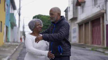 50 'li yaşlarda Afro-Amerikan yetişkin bir çocuğun şehir sokaklarında yaşlı annesine sarılmasına. 80 'lerin hanımı ve aile bakıcısı arasındaki gerçek sevgi bağı.