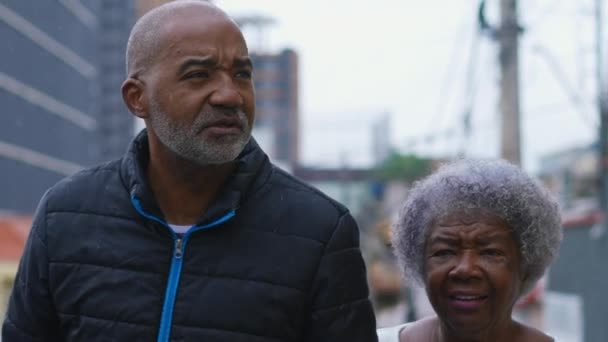 真正的家庭护理 50多岁的非洲裔美国人和80多岁的母亲在城市里一起散步交谈 象征着爱情和支持 — 图库视频影像