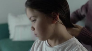 Anne ve babası gece yatmadan önce çocukların saçlarını tarıyor. Anne saçlarını tararken küçük kızın yüzünü yakından tarıyor.