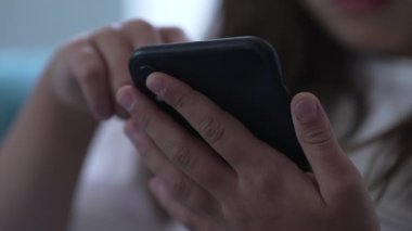 Cep telefonu cihazını tutan çocuğun elleri. Çocuk modern teknolojiyi kullanarak telefon ekranına bakıyor sosyal medyada geziniyor