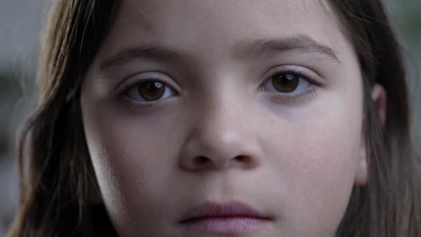 厳粛な空白の表現でカメラを見ている子供の顔のタイトなクローズアップ リトルガールの肖像 — ストック動画