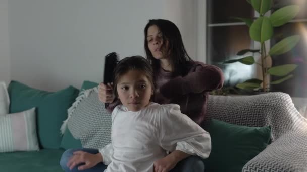 Μητέρα Χτενίζει Μαλλιά Της Κόρης Της Καθισμένη Στον Καναπέ Βράδυ — Αρχείο Βίντεο