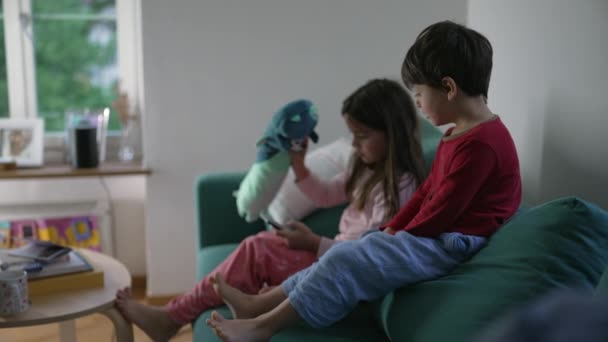 Lillebror Søster Kigger Mobilskærm Mens Sidder Sofaen Stuen Børn Hypnotiseret – Stock-video