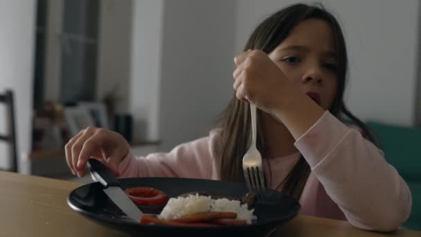 小女孩在家享受自制的晚餐 8岁的孩子在吃饭 自己用叉子和小刀切食物 — 图库视频影像