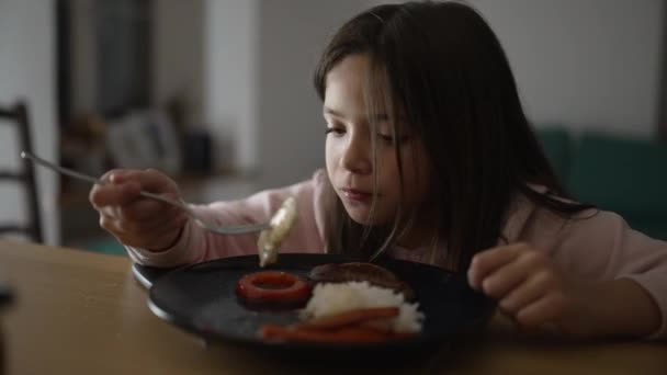 小女孩在家里吃饭 孩子们享受着晚上自制的盘子 8岁的孩子在吃饭 — 图库视频影像