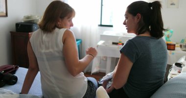 Yatak odasında konuşan ve konuşan iki bayan arkadaş.