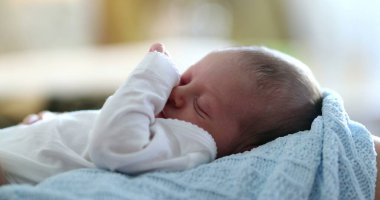 Adorable newborn baby infant waking up from nap