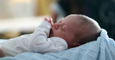 Close-up of newborn baby face waking up from nap