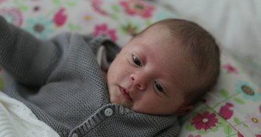 Baby newborn baby infant awake in bed observing first month of life
