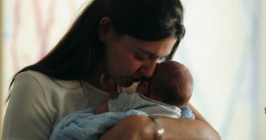 Mother calming newborn baby showing love and affection