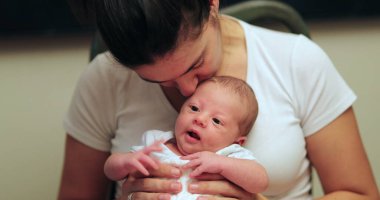 Mother holding newborn baby first month of life portrait