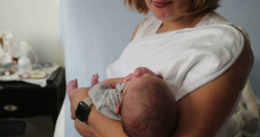 Happy new young mother holding newborn baby infant in arms