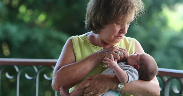 Grand-mother holding newborb baby infant interaction calming grand-son