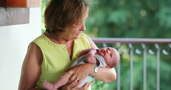 Grand-mother holding newborn baby infant in arms