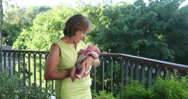 Grand-mother holding newborn grand-son baby infant