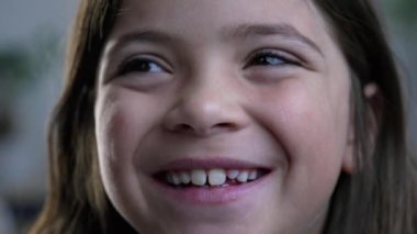 Kameraya gülümseyen neşeli küçük kızın makro yakın çekimi, 8 yaşındaki mutlu bir çocuğun sıkı yüz hatları.