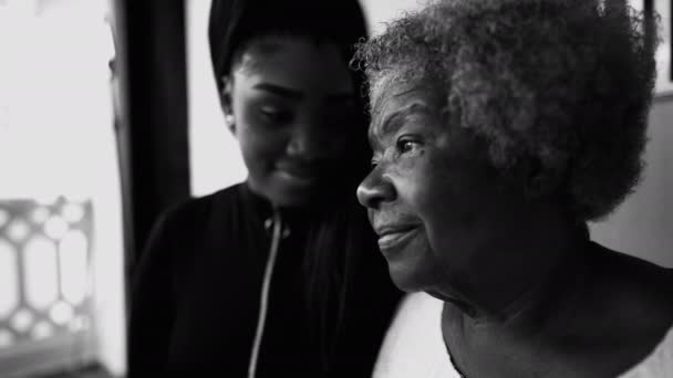 心事重重的非洲裔美国老年妇女凝视着远方 凝视着沉思的目光 背景中的孙女 支持着80多岁的老奶奶 黑人和白人 — 图库视频影像