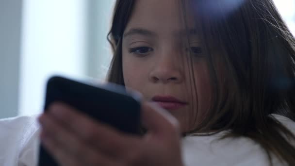 小女孩紧闭着脸 带着严肃而无聊的表情拿起电话 网上观看儿童内容 — 图库视频影像