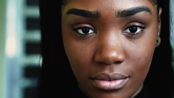 一个严肃的年轻黑人女子的宏观特写 面容严肃地直视着相机 20多岁的南美成年非洲裔女孩 — 图库视频影像