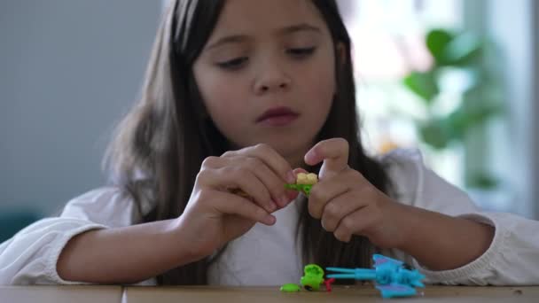 トイアセンブリに焦点を当てた8歳の少女 子供の遊び心の詳細なクローズアップ — ストック動画