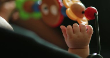 Baby hand playing with toy inside crib