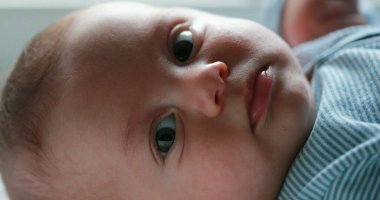 Baby newborn closeup face looking to camera