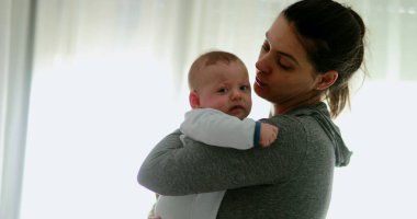 Authentic mother consoling crying baby newborn boy